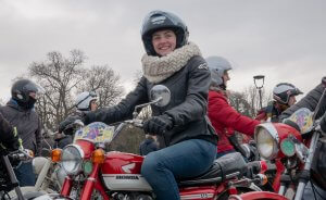 Fille souriant sur une moto honda rouge